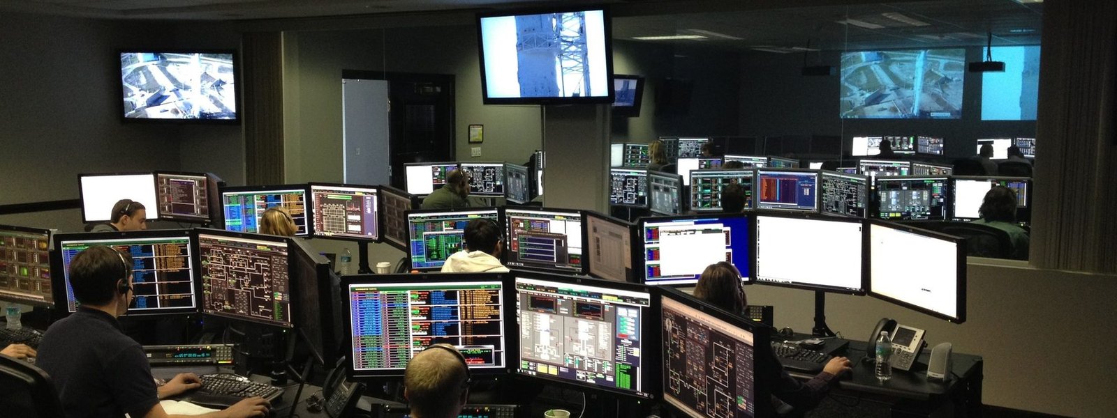 An operations floor with analysts working across banks of monitors