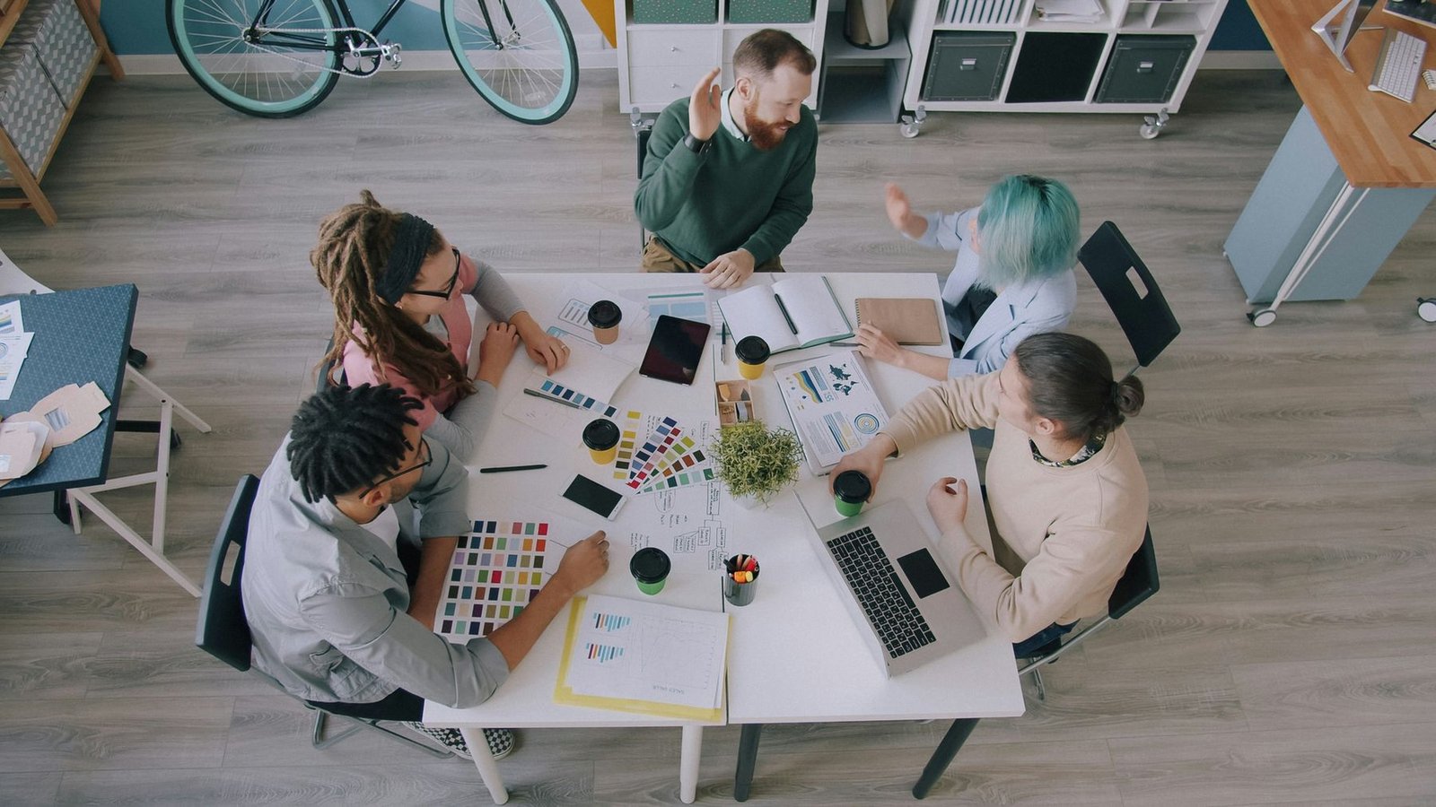 A team working around a table covered in colour swatches and charts